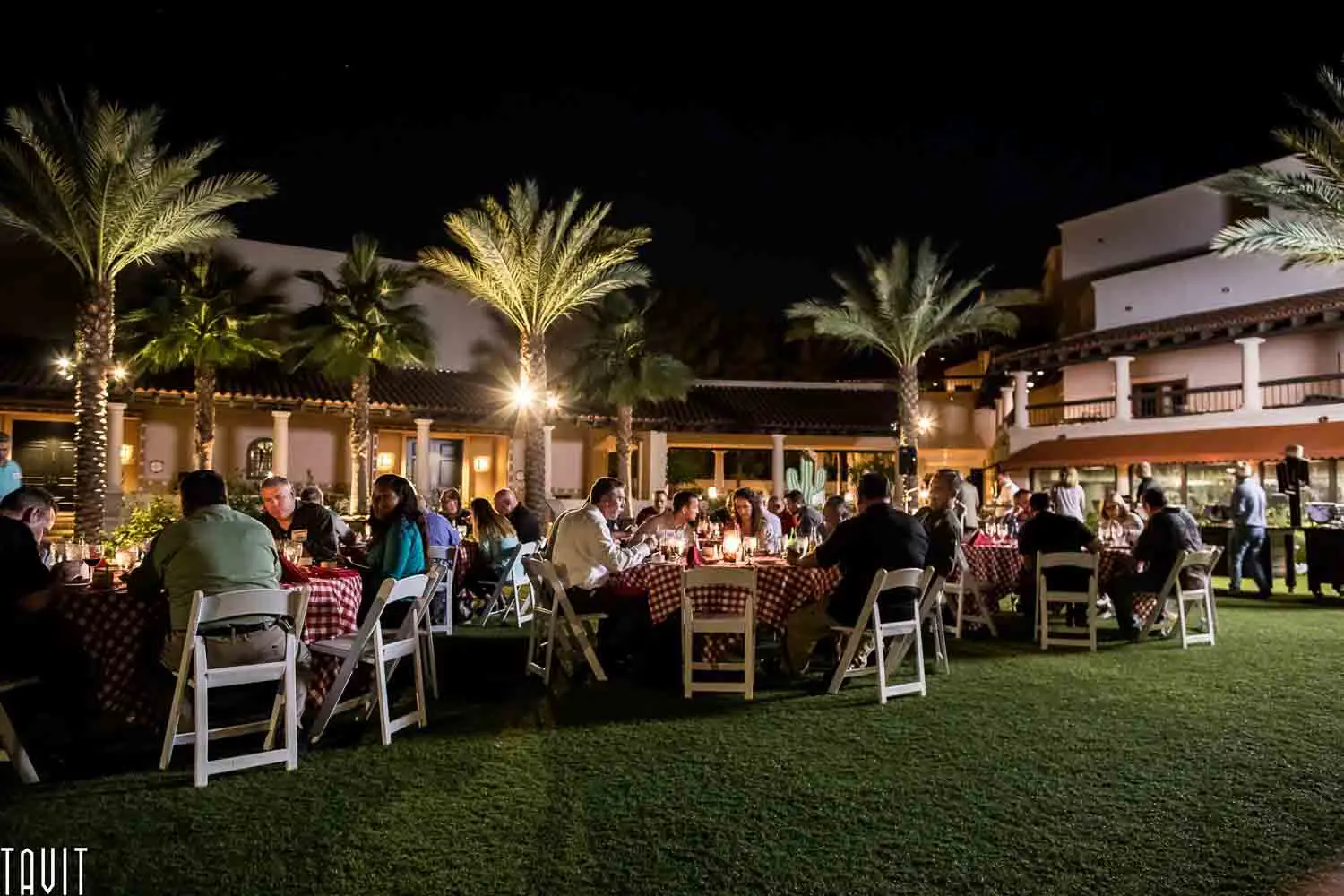 attendees of a corporate event sitting outside at round tables eating