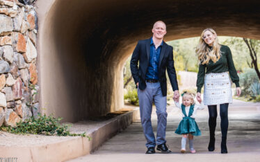Father and mother holding hand of daughter