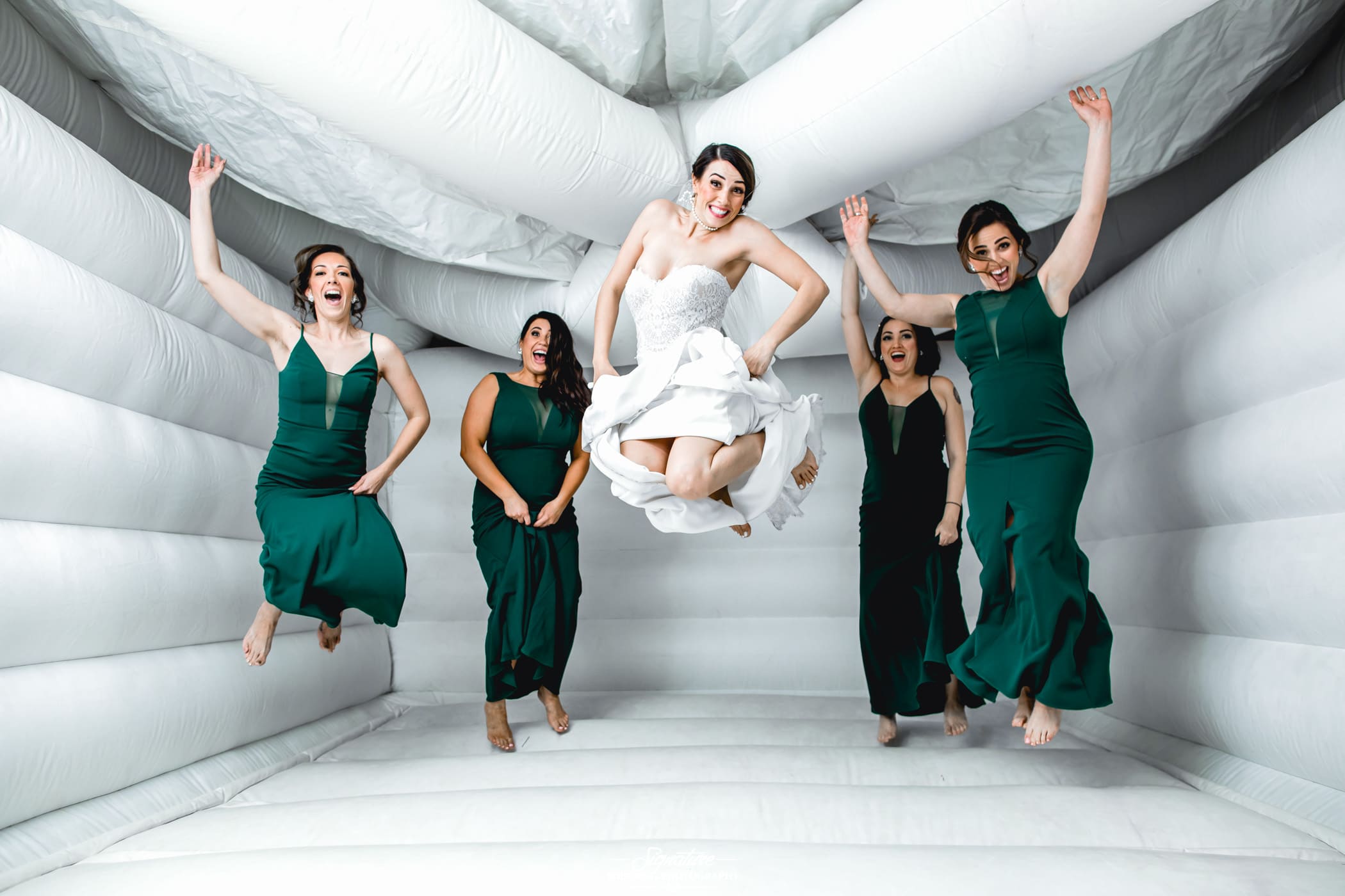 Bridal party jumping in bounce house