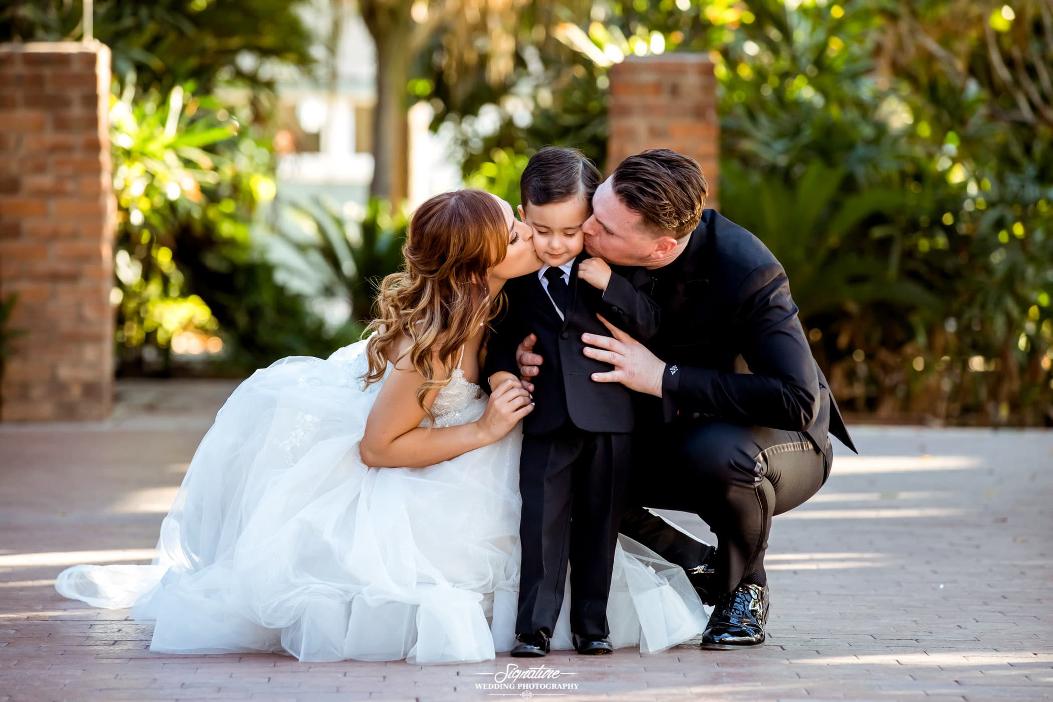 Bride and groom kissing son
