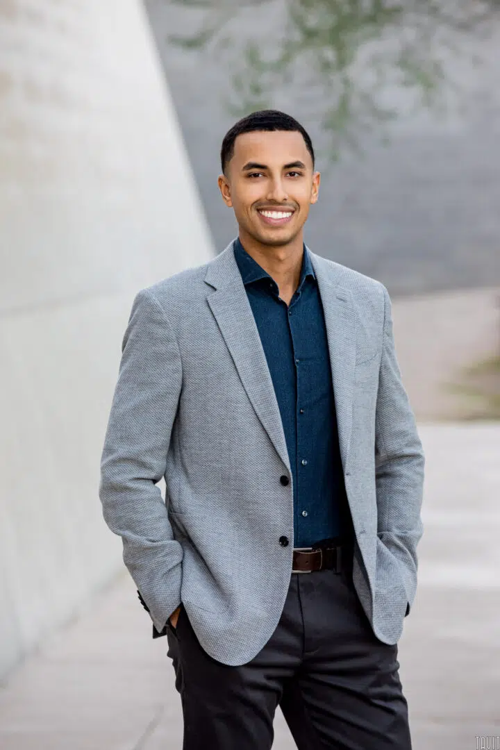 Professional headshot of a man in a grey jacket