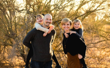 Husband and Wife giving daughters piggie back rides