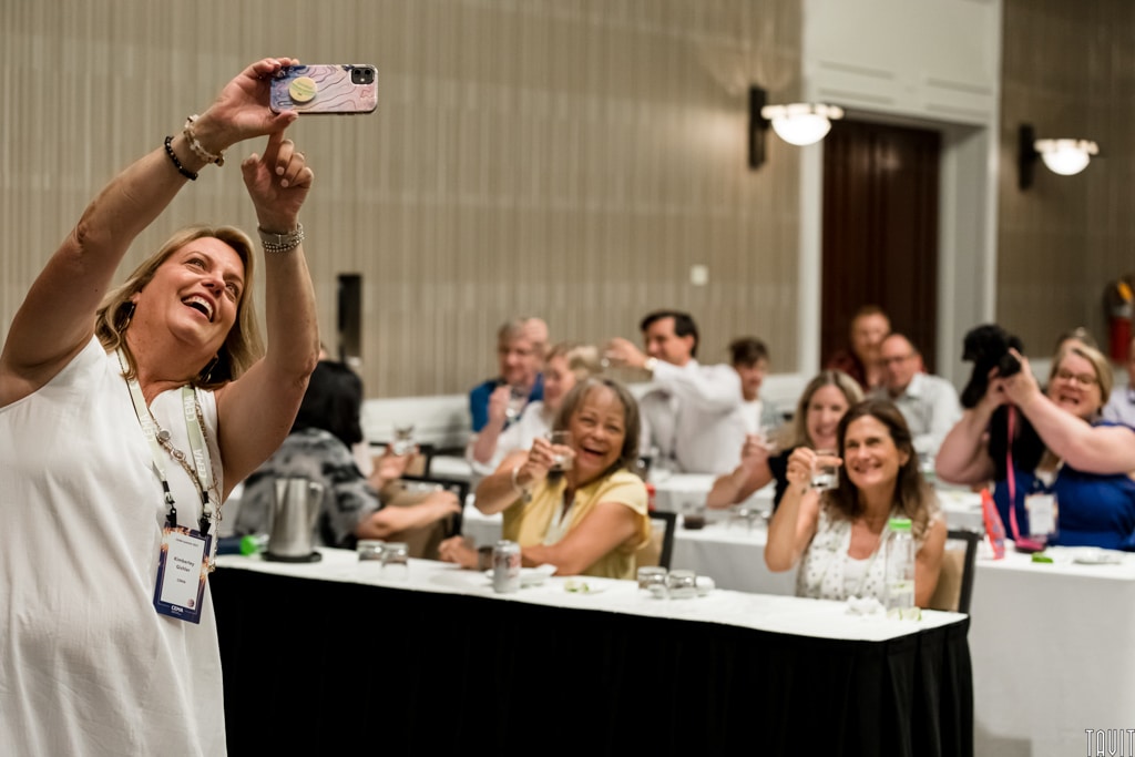 Woman taking selfie with other women at event
