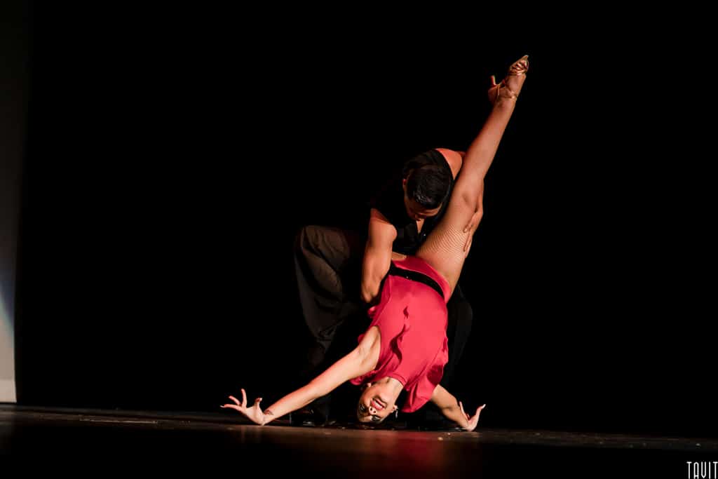 Man dancer holding woman dancer upside down