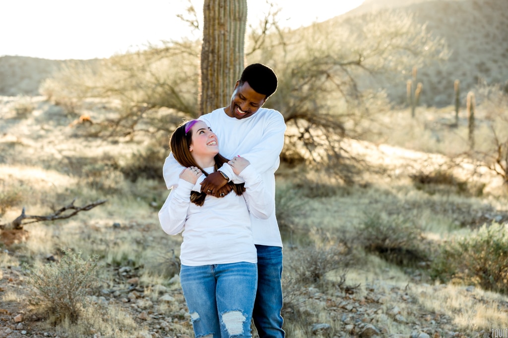 Dad and daughter hugging and smiling at each other in desert