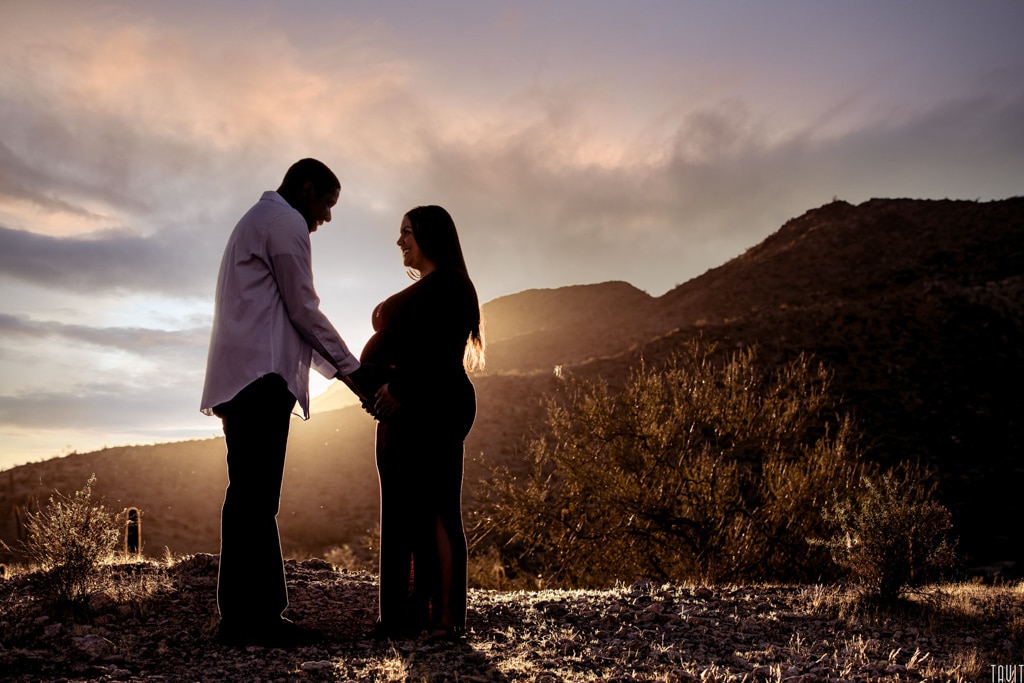 Silloutte couple at sunset in desert for maternity shoot