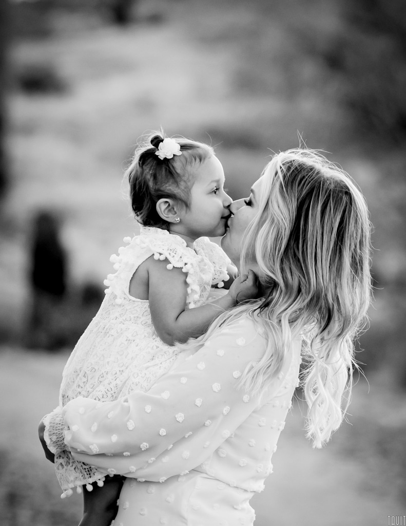 Mom kissing daughter family photo