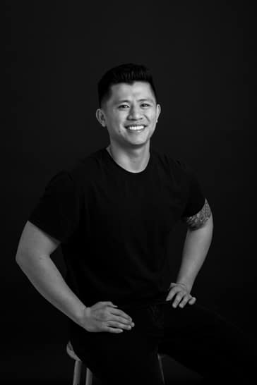 Jaron sitting hands on hips business headshot black and white