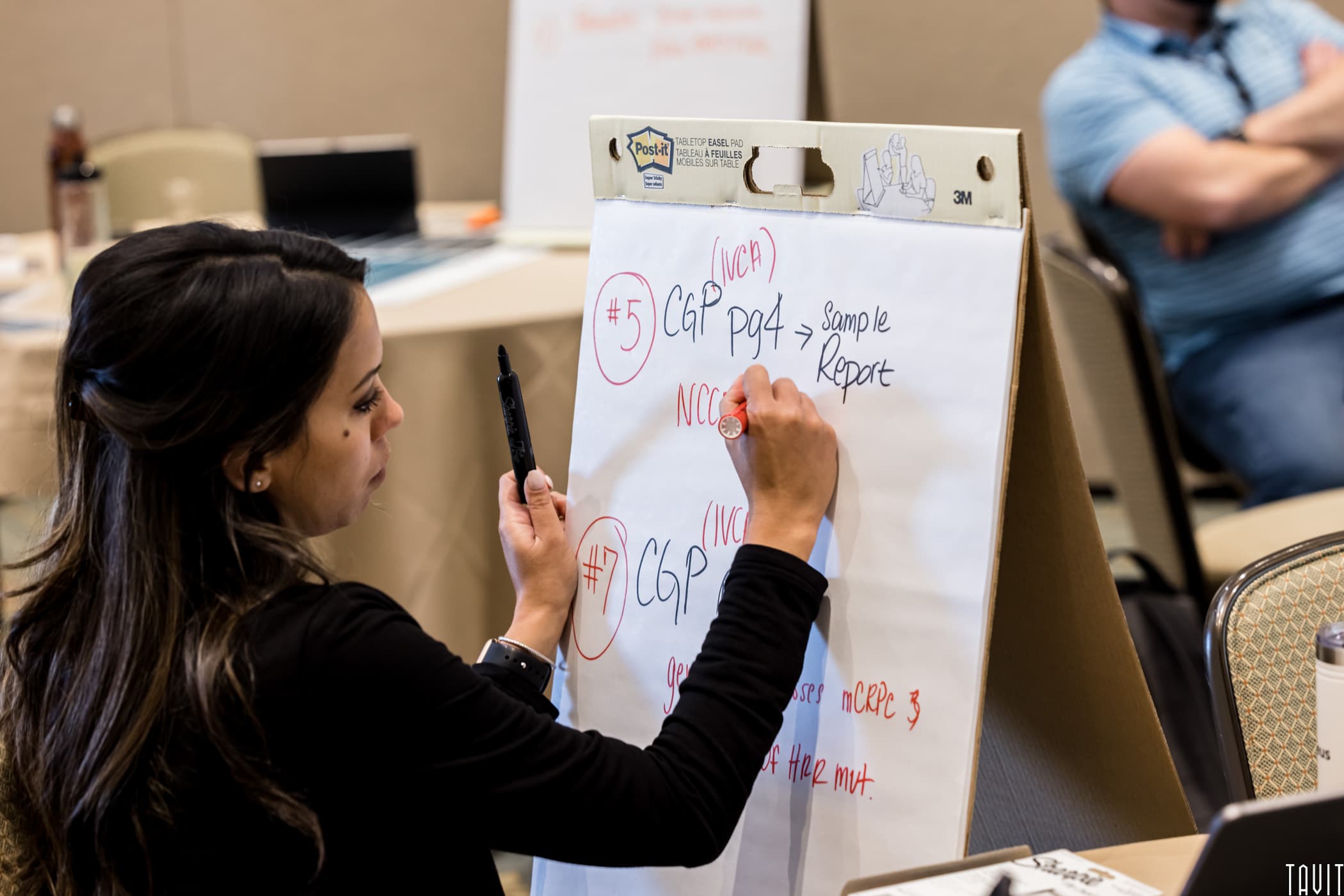 Woman writing on poster board for business event