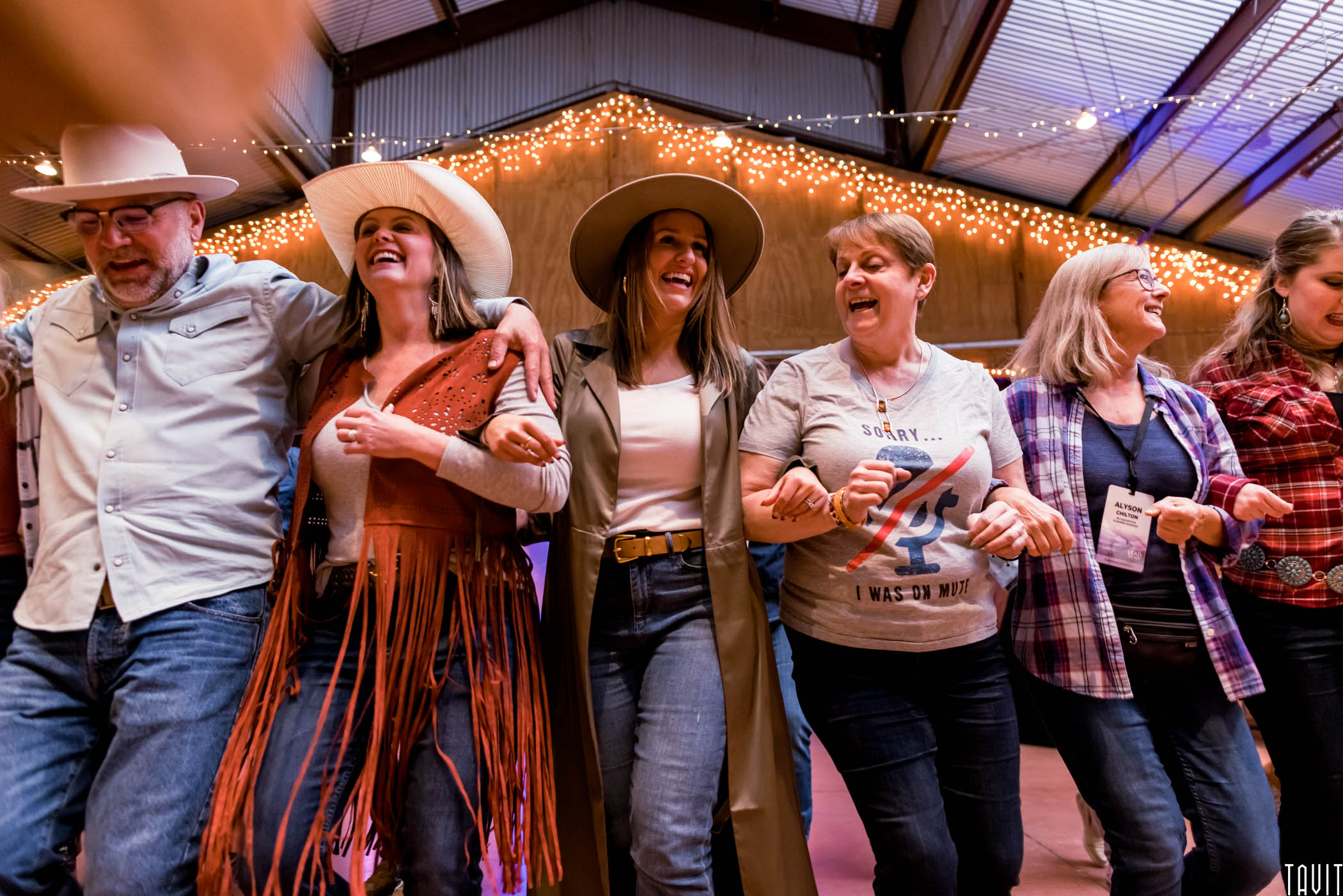 Group of people line dancing with arms linked