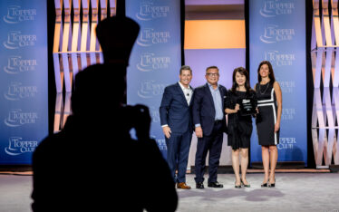Group of people standing with reward plaque