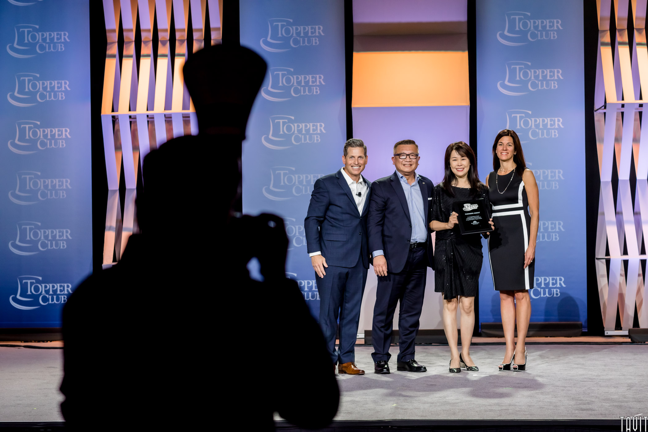 Group of people standing with reward plaque