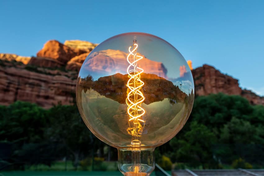 Edison style lightbulb in front of desert mountain