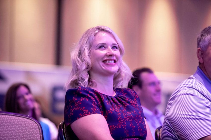 Woman smiling in crowd at business event