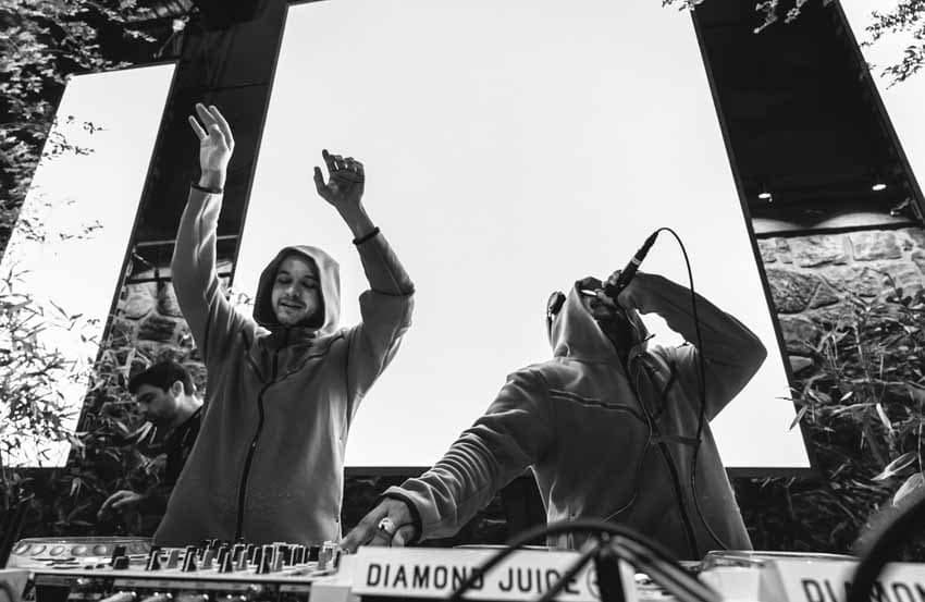DJs on stage with microphone and hands in the air black and white