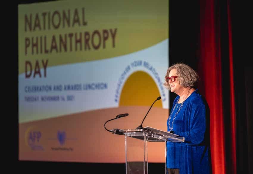 Man standing at podium giving presentation for National Philanthropy Day
