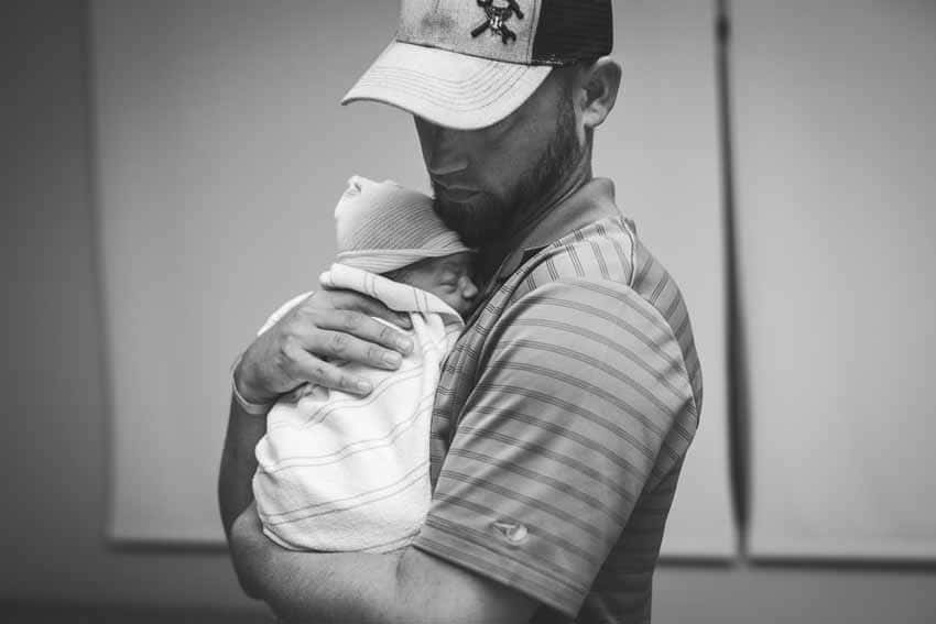 Father holding new baby black and white