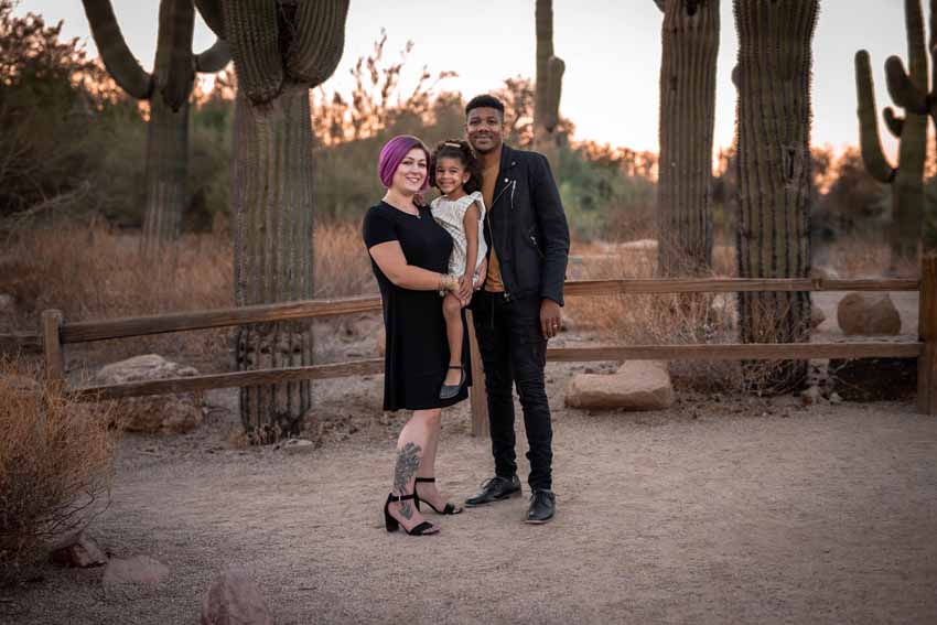 Family smiling in front of cacti