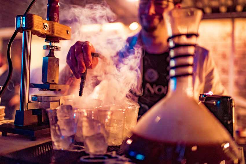 Bartender adding smoke to cocktails