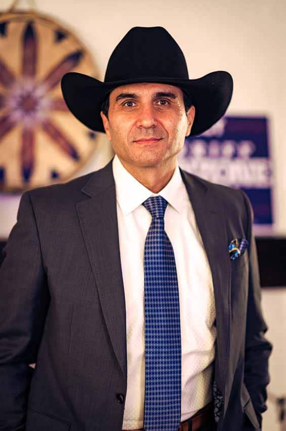 Headshot of man in cowboy hat and tie