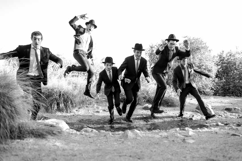 Group of men in suits jumping over water