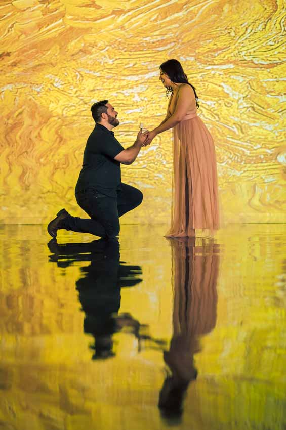 Man on one knee proposing to woman in pink dress