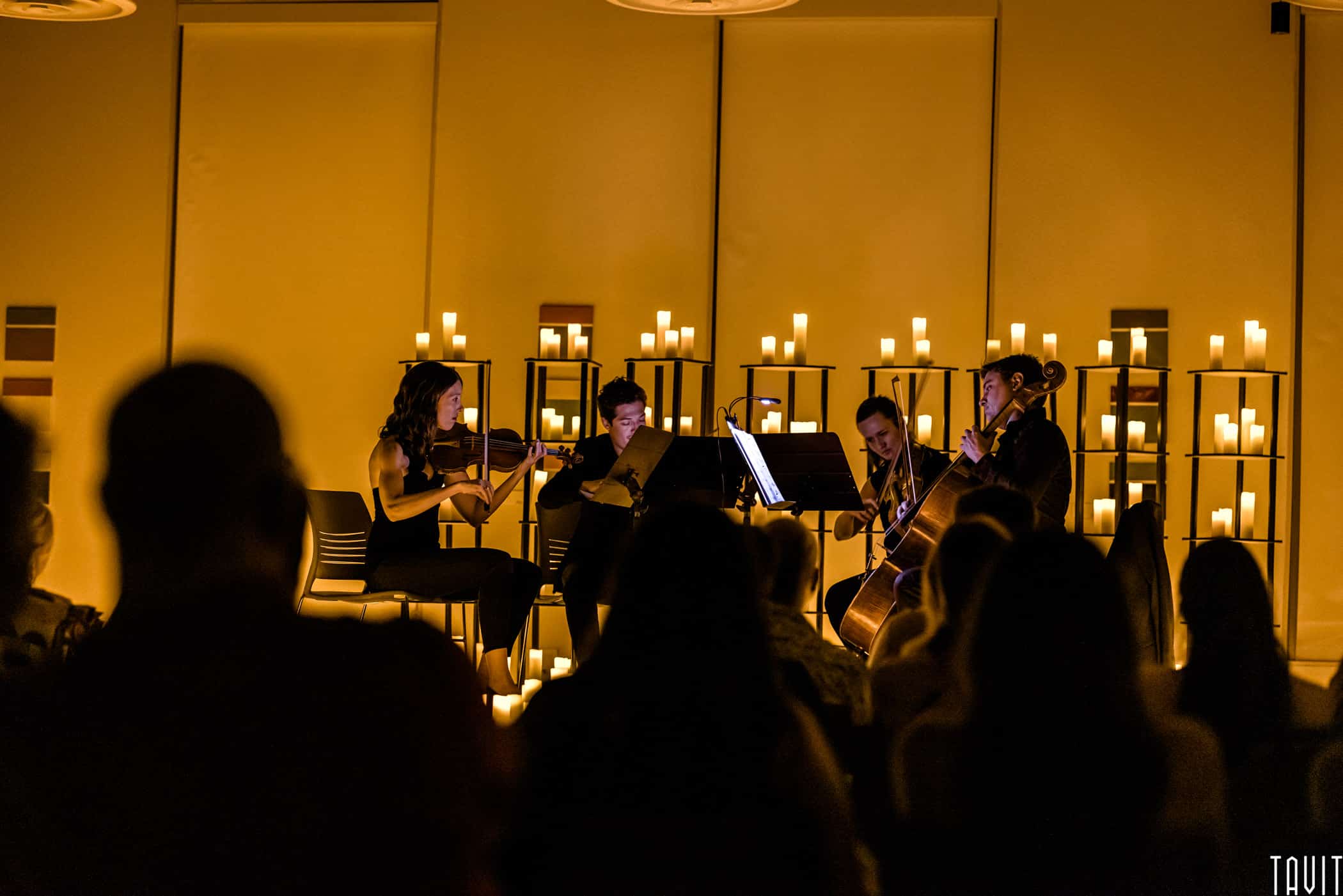 String quartet playing surrounded by candles