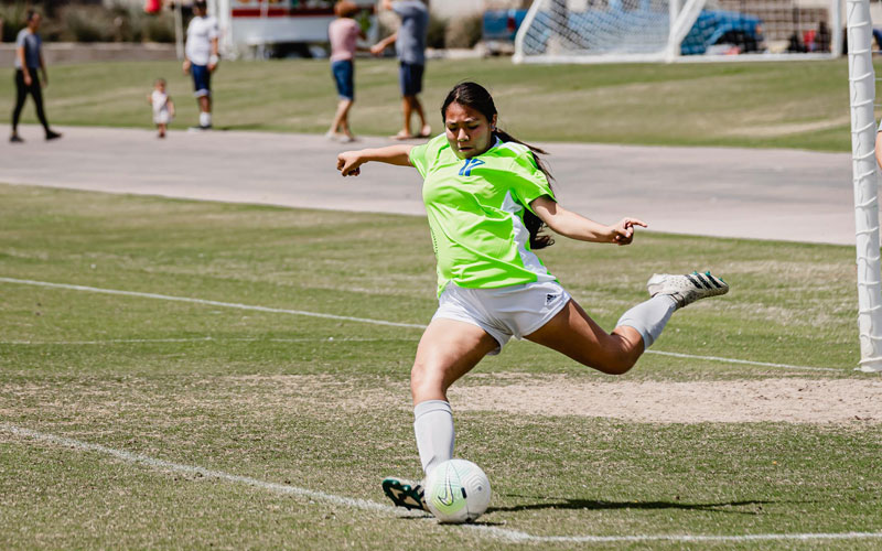 Girl kicking soccer ball