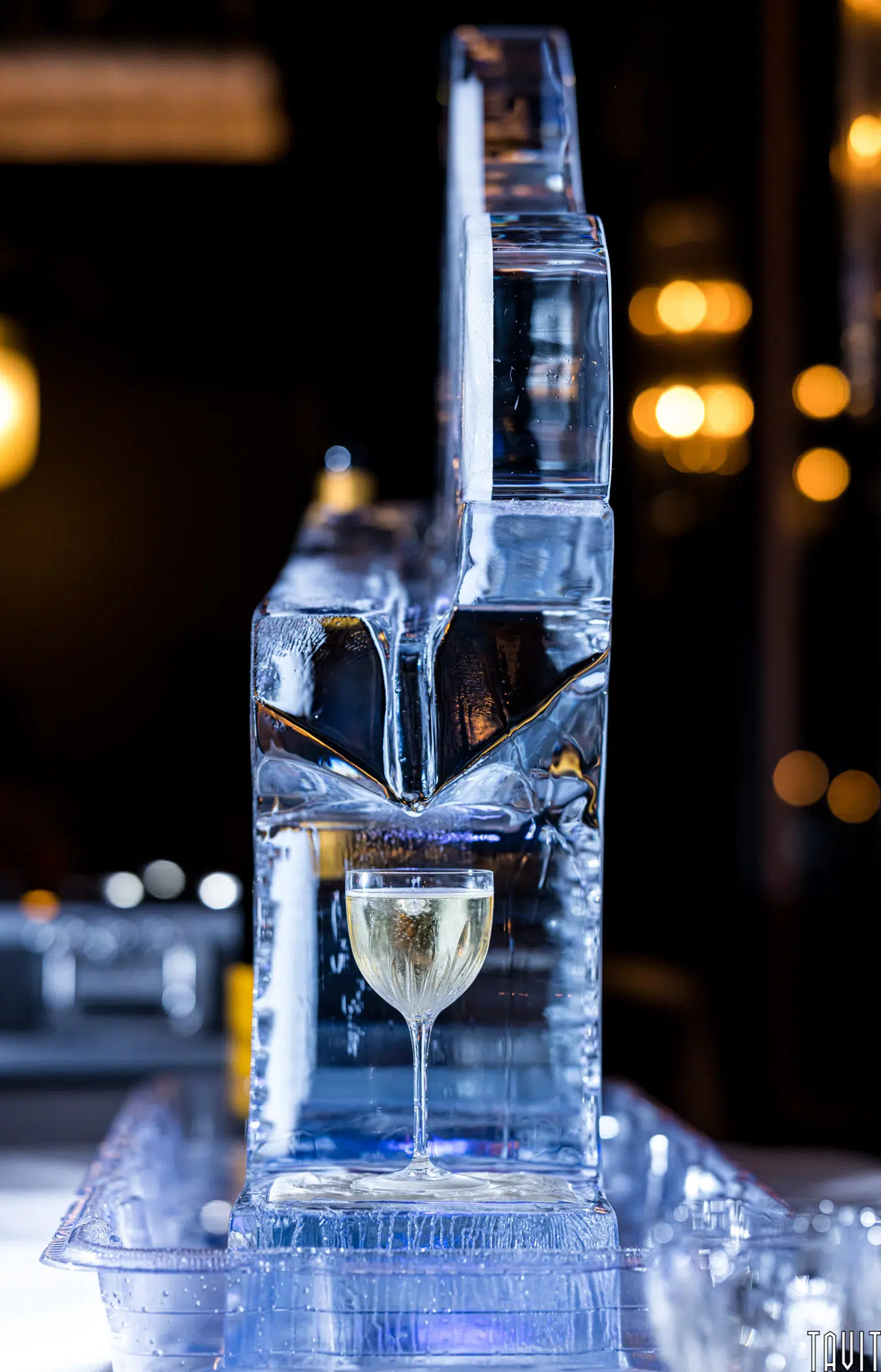 Cocktail being poured off of an ice statue
