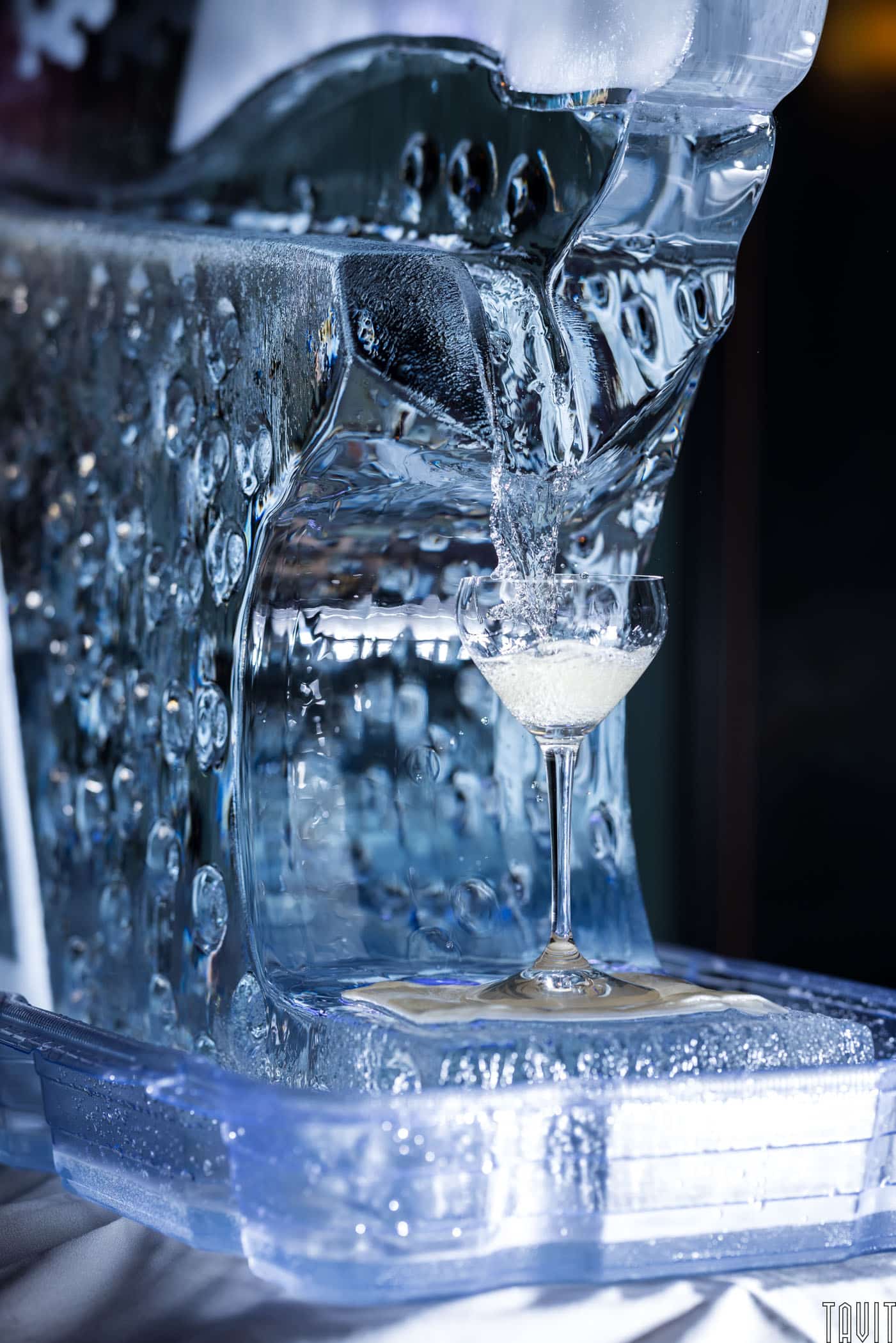 Cocktail being poured off of an ice statue