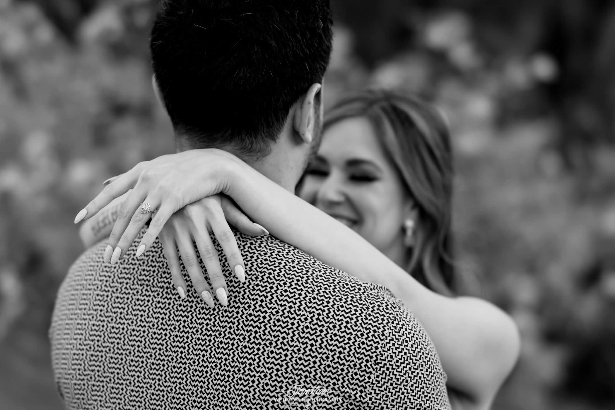Woman's arms around man's shoulders black and white