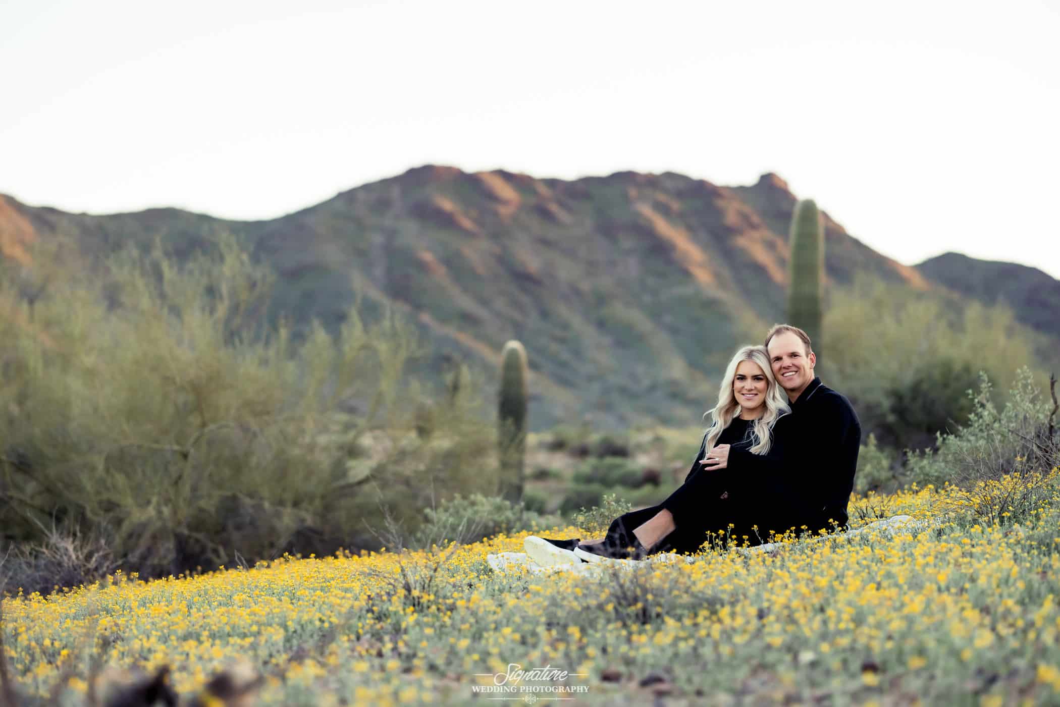 Couple sitting together in front of desert mountain
