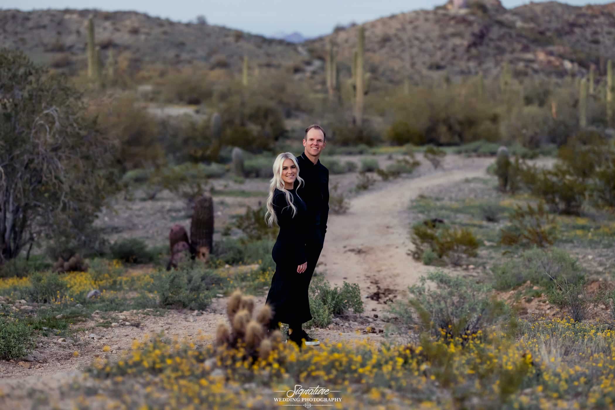 Couple holding hand standing on desert path