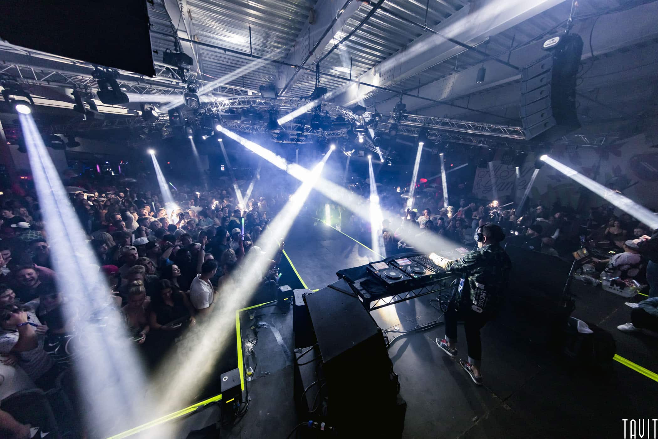 DJ on catwalk stage with lights