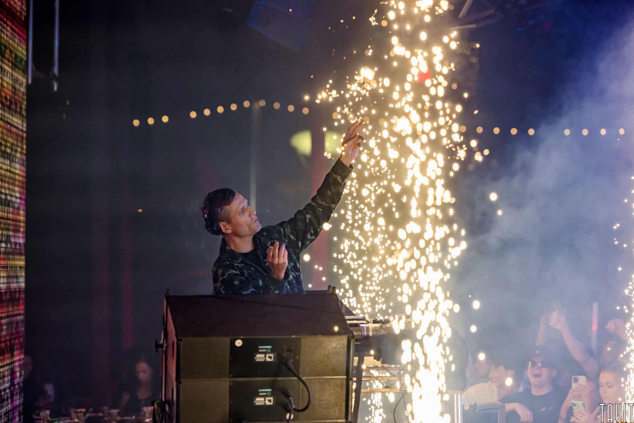 DJ on stage in behind spark fountain