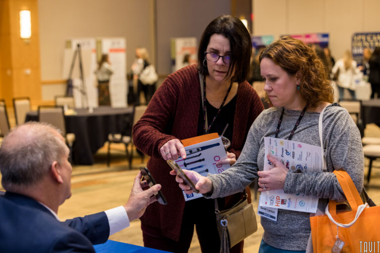 woman and man comparing smartphones at a conference
