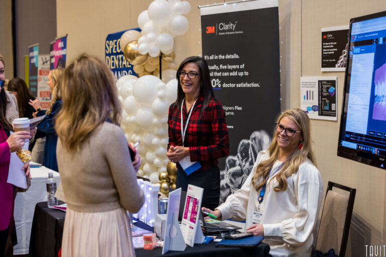 women at a booth at a conference