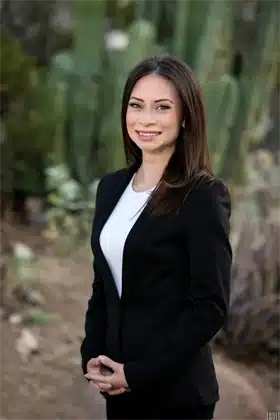 business headshot of woman in a black suit with cactus in the background