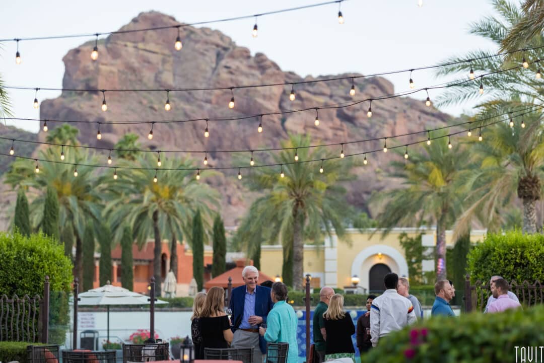 outside shot of people socializing with AZ mountain in the backdrop