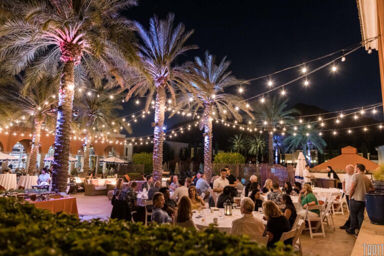 outdoor event with string lights and palm trees at night