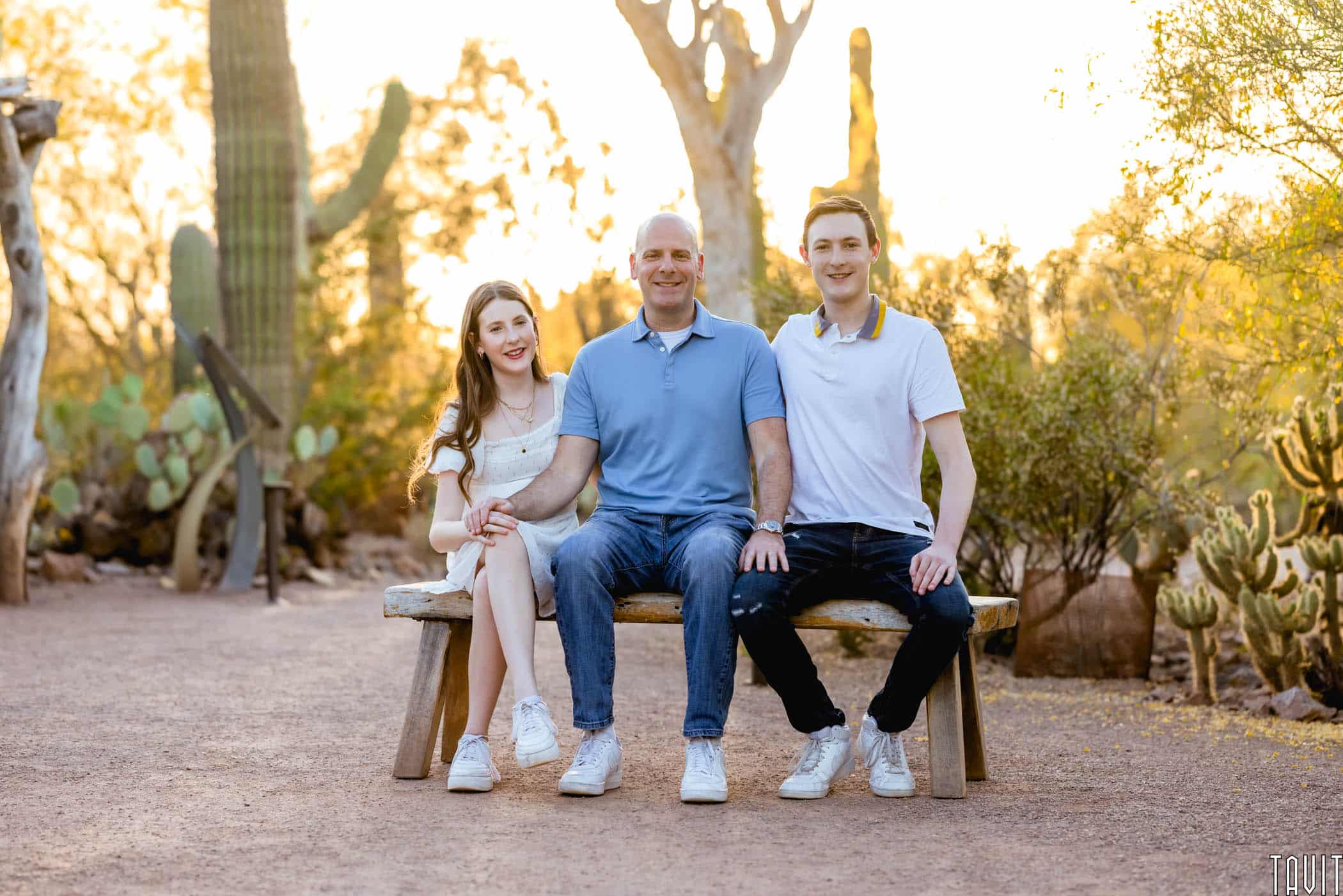 father with son and daughter on a bench with a desert background