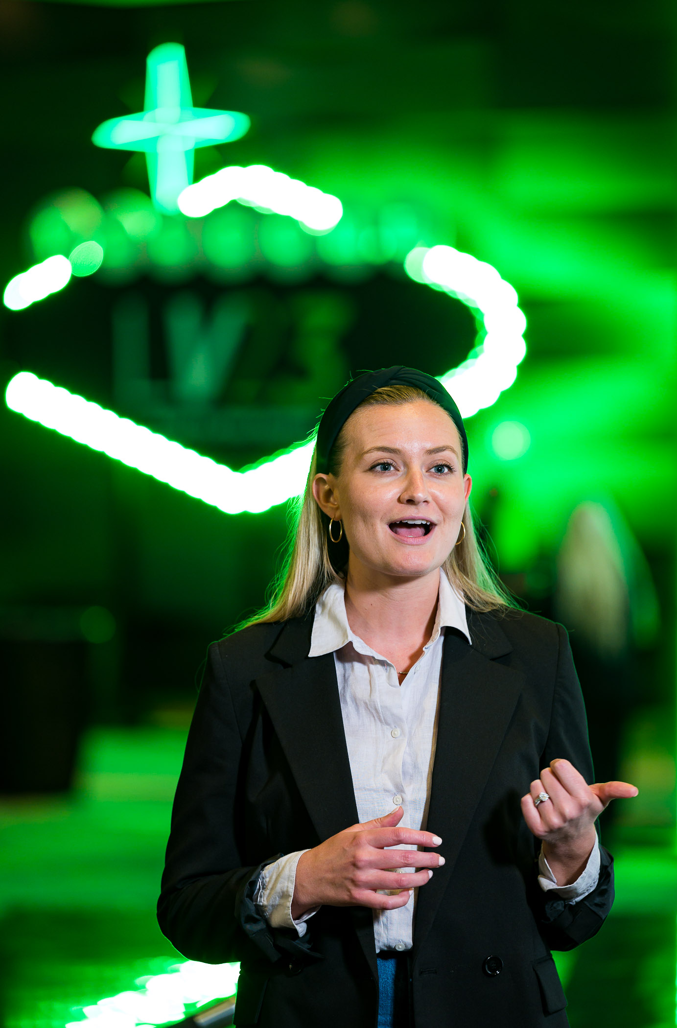 Woman in front of green neon sign