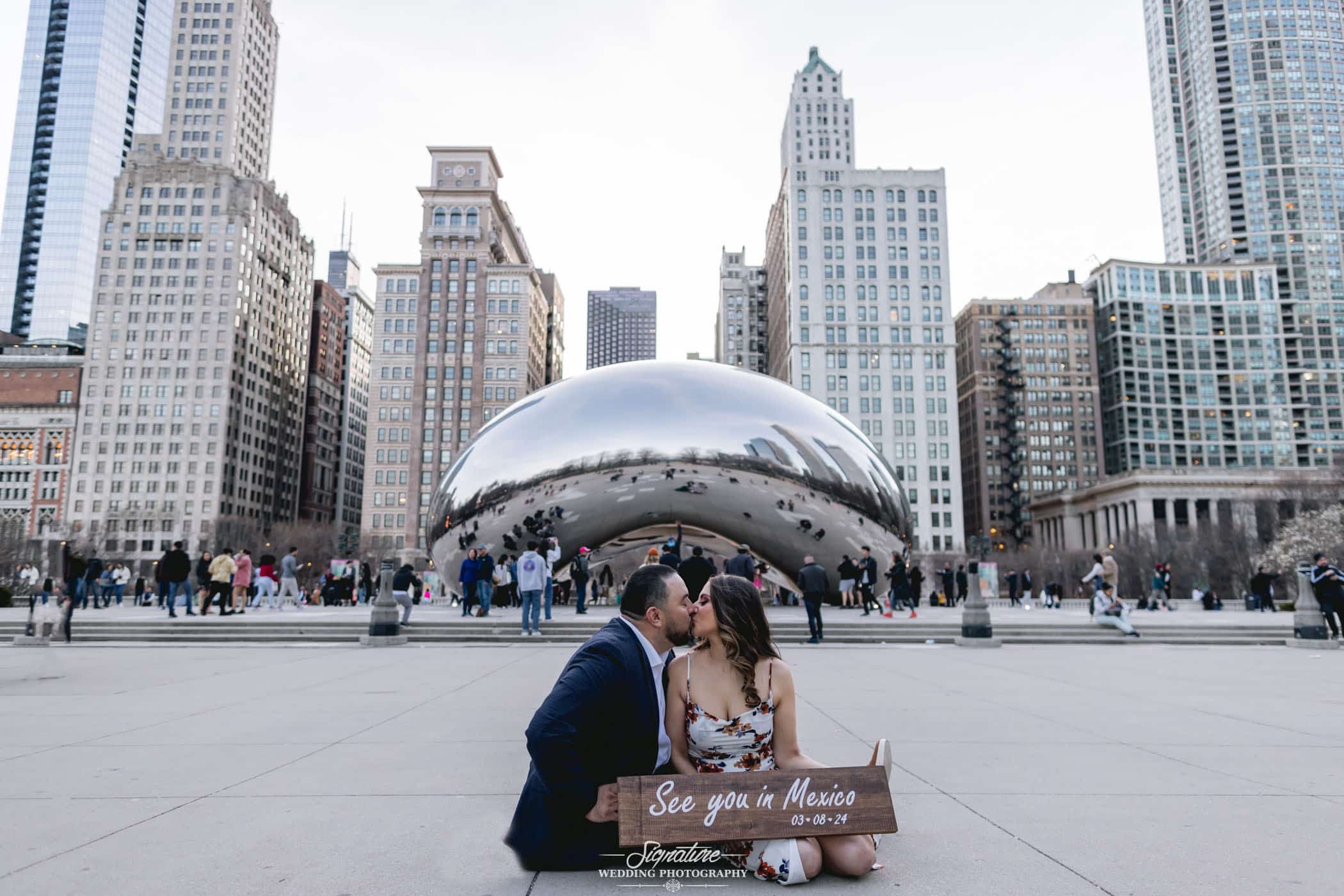 Couple kissing in front of silver bean