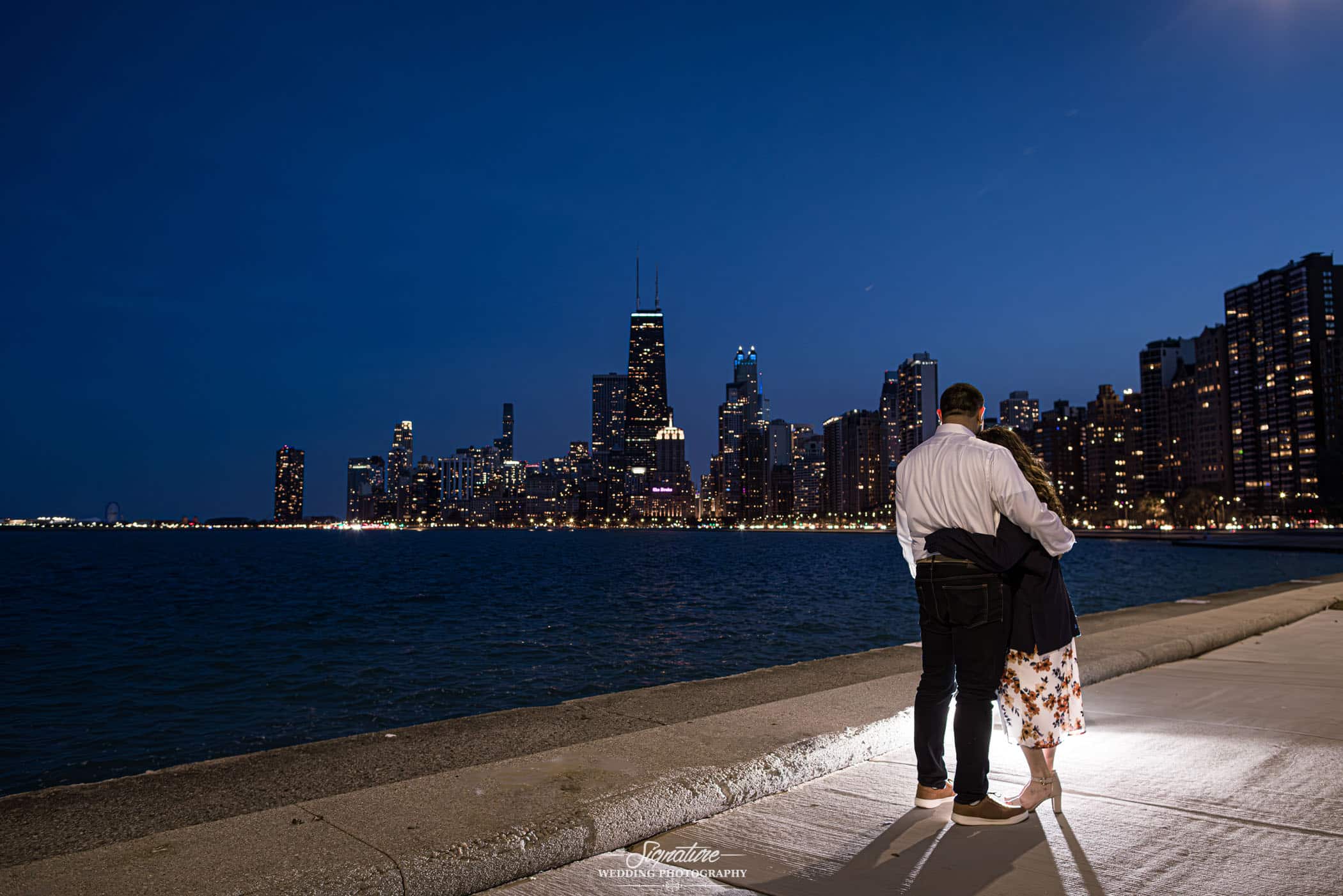 Couple standing in front of water near city skyline