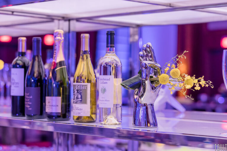 Wine bottles on shelf with metal hand and flowers