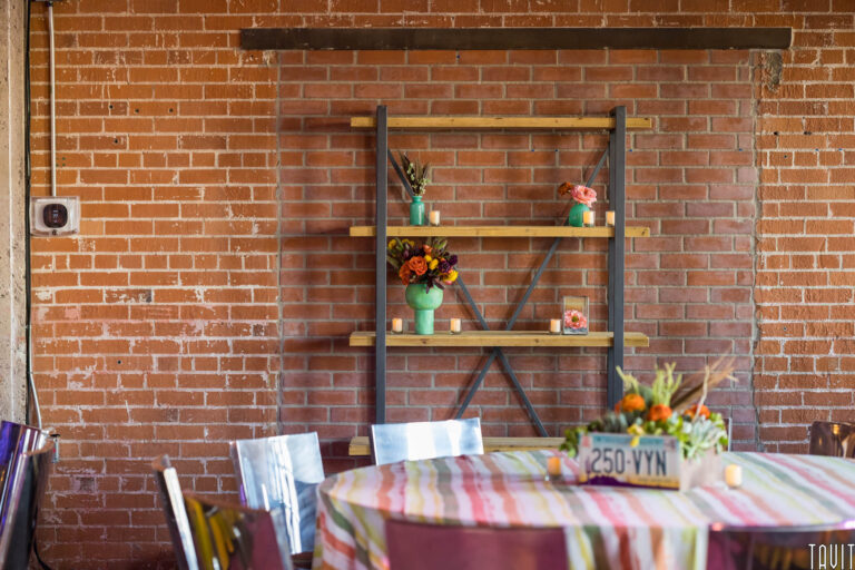 Table and chairs in front of brick wall