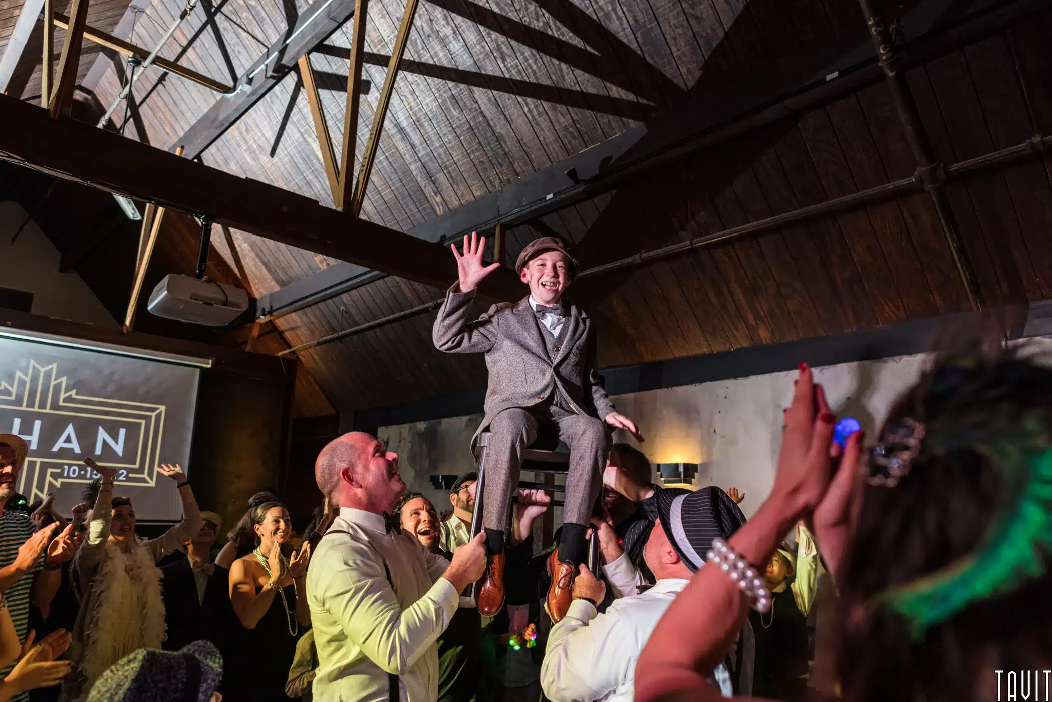 young man being lifted up in a chair at his Bar Mitzvah