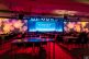 Large conference room with rows of chairs and tables facing a brightly lit stage. The backdrop reads "Stronger Together" with colorful circular light patterns projected across the walls, perfectly captured by a professional Scottsdale event photographer.